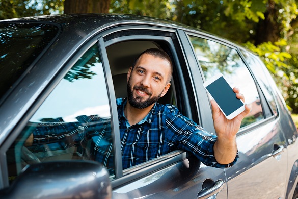 Man driving holding phone out the window