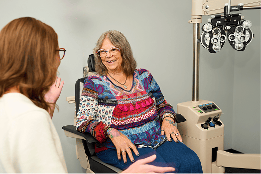 woman-in-an-eye-exam-chair-converses-with-another-woman Glaucoma